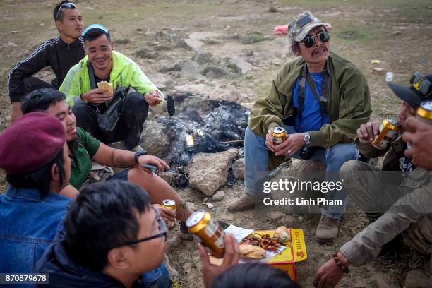 Minsk enthusiasts chat over a beer after the off-road tournament on November 5, 2017 in Hanoi, Vietnam. A new generation of Vietnamese have started...