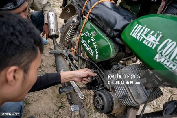 Minsk motorcycle enthusiasts help each others fine-tuning and fixing their vehicles before the off-road race on November 5, 2017 in Hanoi, Vietnam. A...