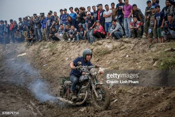 Minsk motorcyclist tries try to get over the dirt slope at an off-road race on November 5, 2017 in Hanoi, Vietnam. A new generation of Vietnamese...