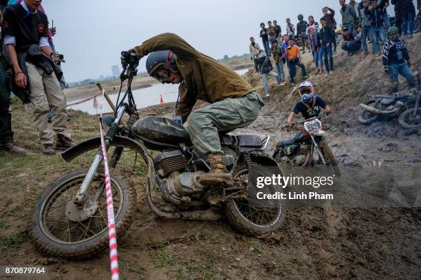 Minsk motorcyclists try to get over the dirt slope at an off-road race on November 5, 2017 in Hanoi, Vietnam. A new generation of Vietnamese have...