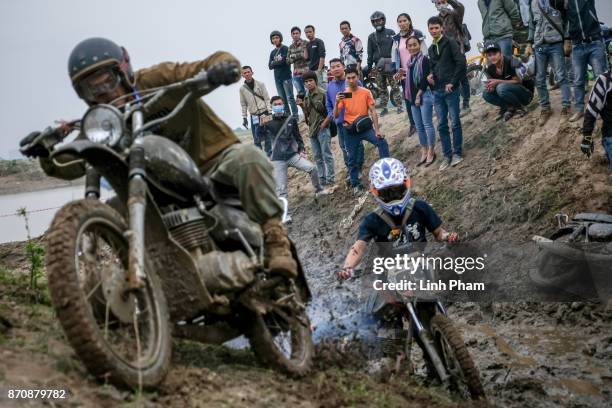 Minsk motorcyclists try to get over the dirt slope at an off-road race on November 5, 2017 in Hanoi, Vietnam. A new generation of Vietnamese have...