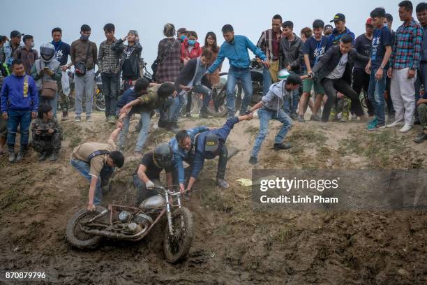 Minsk motorcyclist tries try to get over the dirt slope with the help of audiences at an off-road race on November 5, 2017 in Hanoi, Vietnam. A new...