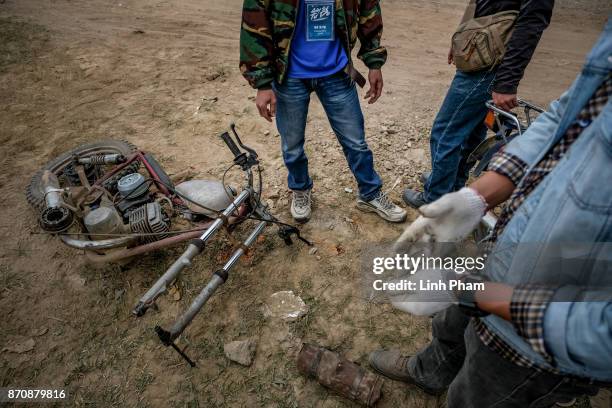 Minsk motorcycle enthusiasts help each others fine-tuning and fixing their vehicles before the off-road race on November 5, 2017 in Hanoi, Vietnam. A...