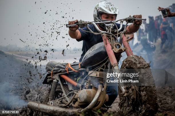 Minsk motorcyclist tries try to get over the dirt slope at an off-road race on November 5, 2017 in Hanoi, Vietnam. A new generation of Vietnamese...