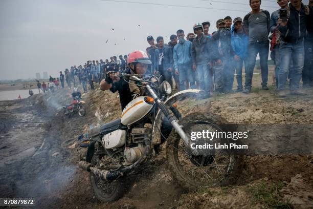 Minsk motorcyclists try to get over the dirt slope at an off-road race on November 5, 2017 in Hanoi, Vietnam. A new generation of Vietnamese have...