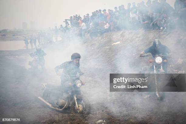 Minsk motorcyclists try to get over the dirt slope at an off-road race on November 5, 2017 in Hanoi, Vietnam. A new generation of Vietnamese have...