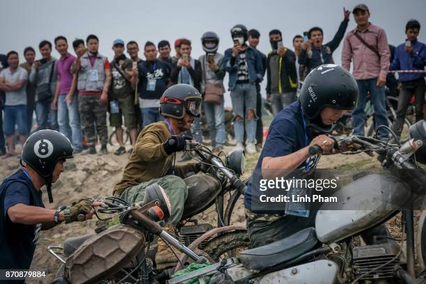 Minsk motorcyclists try to get over the dirt slope at an off-road race on November 5, 2017 in Hanoi, Vietnam. A new generation of Vietnamese have...