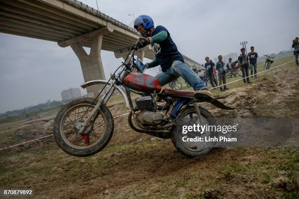 Minsk motorcyclists race at a dirt track on November 5, 2017 in Hanoi, Vietnam. A new generation of Vietnamese have started to ply the roads across...