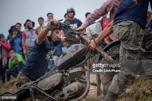 Minsk motorcyclist tries try to get over the dirt slope with the help of audiences at an off-road race on November 5, 2017 in Hanoi, Vietnam. A new...