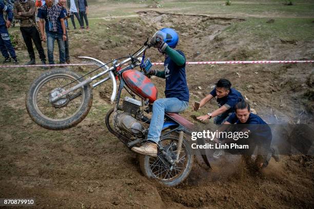 Minsk motorcyclist tries try to get over the dirt slope with the help from audiences at an off-road race on November 5, 2017 in Hanoi, Vietnam. A new...