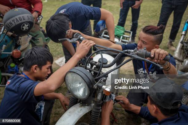 Minsk motorcycle enthusiasts help each others fine-tuning and fixing their vehicles before the off-road race on November 5, 2017 in Hanoi, Vietnam. A...