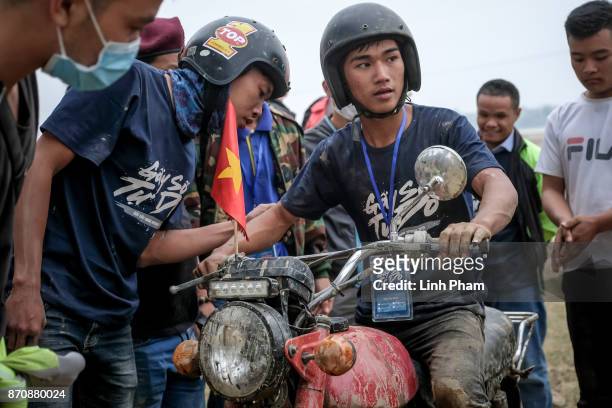 Thien, 16-years-old Minsk motorcyclist, gets advices from his friends during the off-road race on November 5, 2017 in Hanoi, Vietnam. A new...
