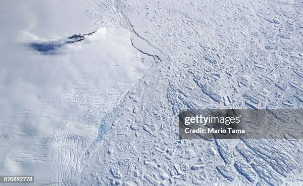 Icebergs and sea ice float next to land ice , as seen from NASA's Operation IceBridge research aircraft, near the coast of the Antarctic Peninsula...