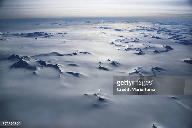 Mountain peaks are seen from NASA's Operation IceBridge research aircraft in the Antarctic Peninsula region, on November 4 above Antarctica. NASA's...