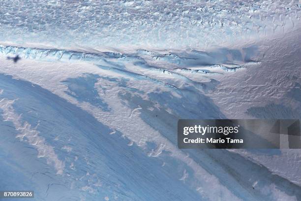 The shadow of NASA's Operation IceBridge research aircraft is cast over blue ice, in the Antarctic Peninsula region, on October 31 above Antarctica....