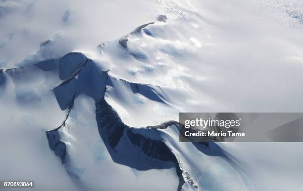 Mountains peek through land ice as seen from NASA's Operation IceBridge research aircraft in the Antarctic Peninsula region, on October 31 above...