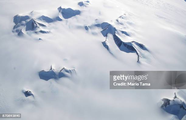 Mountains peek through land ice as seen from NASA's Operation IceBridge research aircraft in the Antarctic Peninsula region, on November 4 above...