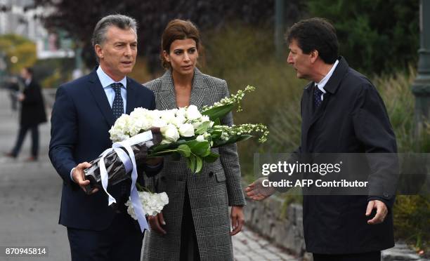 President Mauricio Macri of Argentina along with the First Lady of Argentina Juliana Awada hold flowers as they attend a tribute to victims of the...