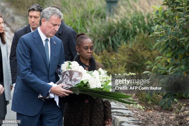 New York City Mayor Bill de Blasio and his wife Chirlane McCray lay a wreath during a ceremony on a bike path in New York on November 6 to pay...