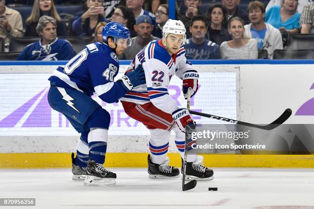 New York Rangers defender Kevin Shattenkirk is closely defended by Tampa Bay Lightning center Gabriel Dumont during the first period of an NHL game...