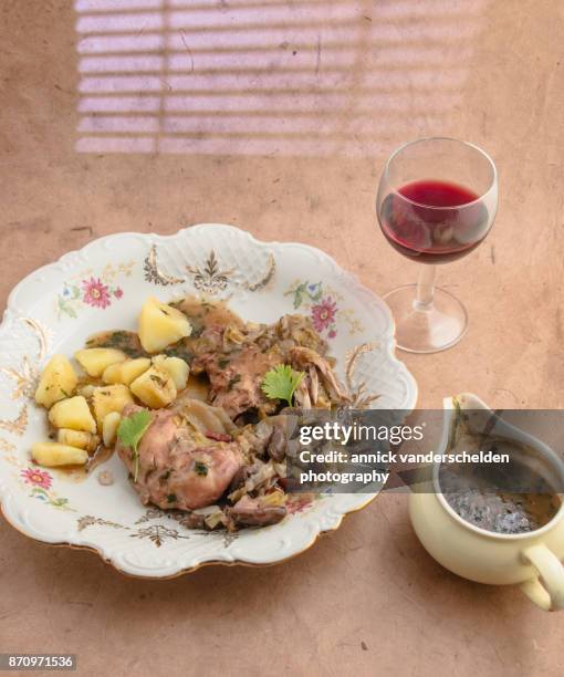 coq au vin with potatoes, sauce and red wine. - coq au vin stock-fotos und bilder