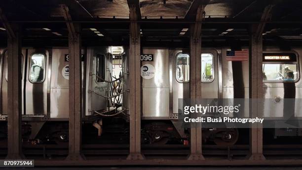 subway train car leaving platform. new york city, usa - vintage commute with the new york city subway stock-fotos und bilder