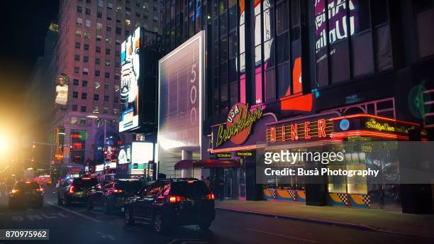 cars driving along west 43rd street near times square, midtown manhattan, new york city - bright lights big city visions of new york at night stockfoto's en -beelden