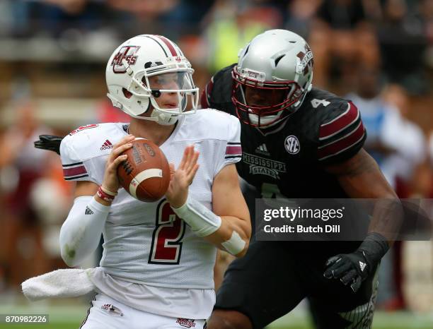 Ross Comis of the Massachusetts Minutemen throws a pass while under pressure from Gerri Green of the Mississippi State Bulldogs during the first half...