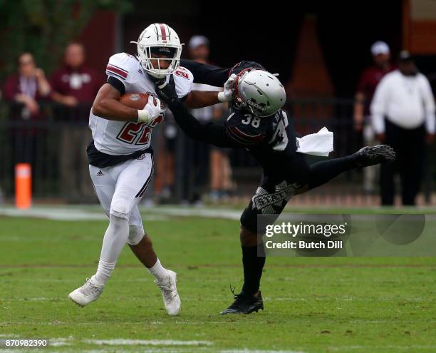 Bilal Ally of the Massachusetts Minutemen tries to break free from the tackle of Johnathan Abram of the Mississippi State Bulldogs during the first...