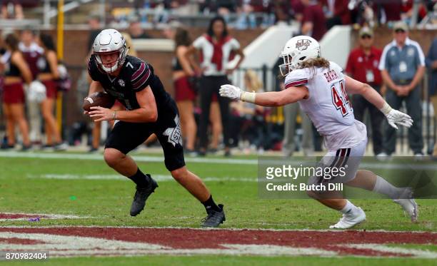 Nick Fitzgerald of the Mississippi State Bulldogs carries the ball as he tries to get around Bryton Barr of the Massachusetts Minutemen during the...