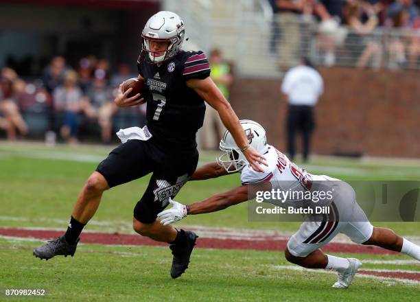 Nick Fitzgerald of the Mississippi State Bulldogs carries the ball around Jesse Monteiro of the Massachusetts Minutemen during the second half of an...