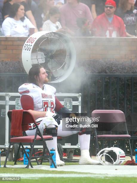 Derek Dumais of the Massachusetts Minutemen cools off on the bench during the second half of an NCAA football game against the Mississippi State...