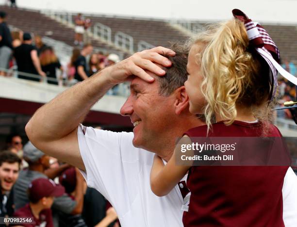 Head coach Dan Mullen of the Mississippi State Bulldogs celebrates with his daughter Breelyn after they defeated the Massachusetts Minutemen 34-23 in...