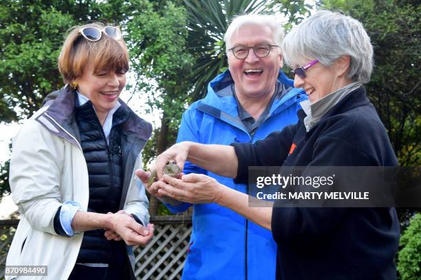 German President Walter Steinmeier with his wife Elke Budenbender hold a Tuatara called Tane with keeper Sue Lum at Zealandia wildlife park in...