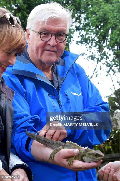 German President Walter Steinmeier with his wife Elke Budenbender hold a Tuatara called Tane with keeper Sue Lum at Zealandia wildlife park in...