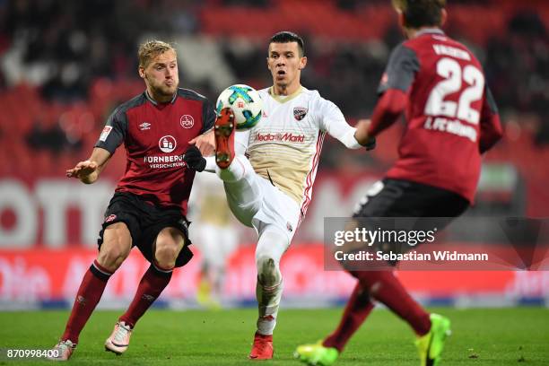 Hanno Behrens of 1.FC Nuernberg and Alfredo Morales of FC Ingolstadt 04 compete for the ball during the Second Bundesliga match between 1. FC...