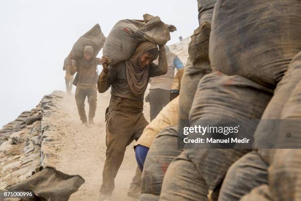 Workers extract and load guano to be used as fertilizer at one of the cliffs of the Asia Island on November 03, 2017 in Lima, Peru. The island is...