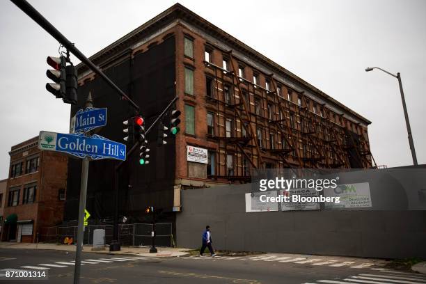 Man passes a redevelopment project at Main Street and Holden Hill Street in Bridgeport, Connecticut, U.S., on Sunday, Nov. 5, 2017. In Connecticut,...