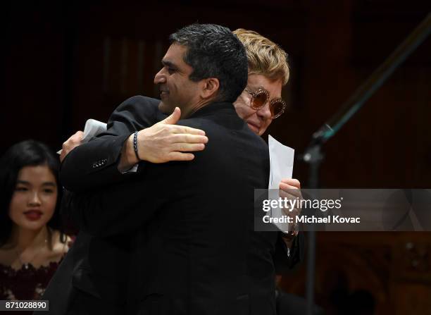Founder Elton John embraces Dean Rakesh Khurana after receiving the Harvard Foundation's Peter J. Gomes Humanitarian of the Year Award for his work...