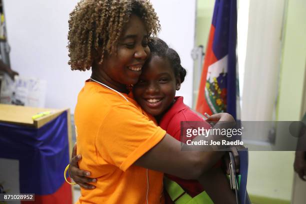 Santcha Etienne hugs Ronyde Christina Ponthieux after she spoke about her father, originally from Haiti, who is here under Temporary Protective...