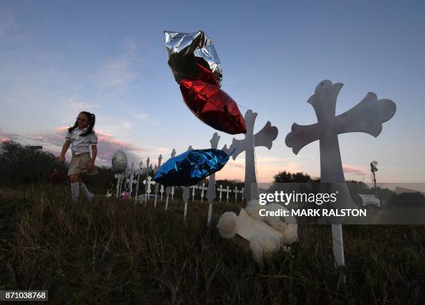 Heather Cooper leaves after placing her favorite doll on a row of crosses for each victim, after a mass shooting that killed 26 people in Sutherland...