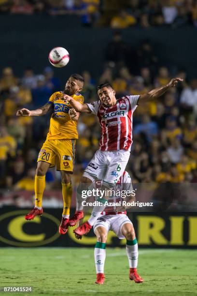 Javier Aquino of Tigres heads the ball with Luis Perez of Necaxa during the 16th round match between Tigres UANL and Necaxa as part of the Torneo...