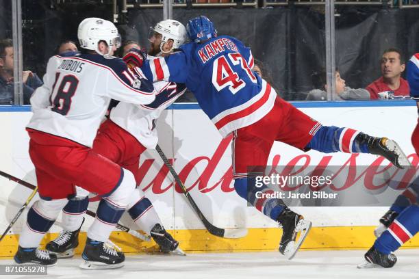 Steven Kampfer of the New York Rangers gets hit by Nick Foligno of the Columbus Blue Jackets at Madison Square Garden on November 6, 2017 in New York...