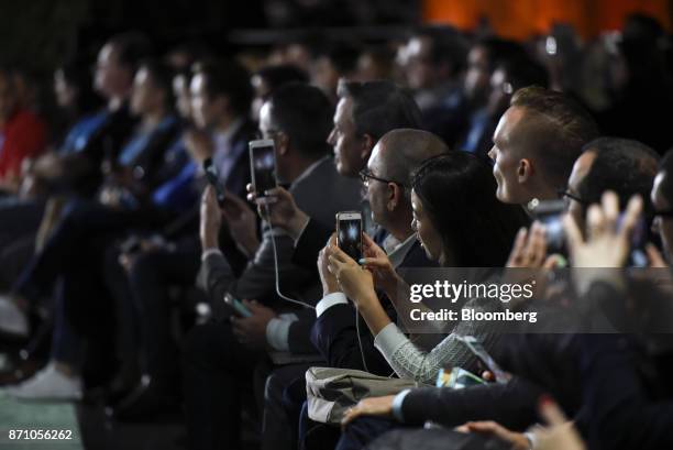 Attendees use their smartphones to take photographs as Marc Benioff, chairman and chief executive officer of Salesforce.com Inc., not pictured,...