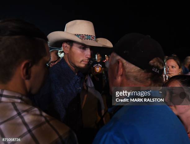 Johnnie Langendorff , one of the two men who chased after suspected killer Devin Kelley, speaks with a man during a vigil in Sutherland Springs,...