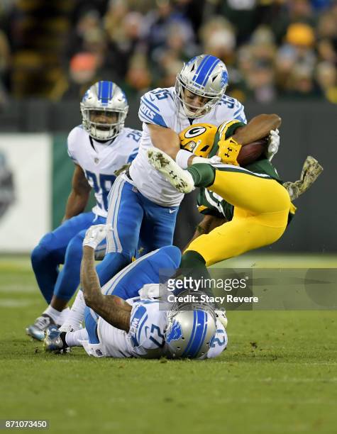 Glover Quin and Miles Killebrew of the Detroit Lions combine for a tackle against Randall Cobb of the Green Bay Packers in the third quarter at...
