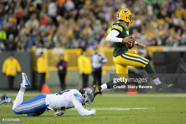 Brett Hundley of the Green Bay Packers avoids a tackle attempt by Ezekiel Ansah of the Detroit Lions in the third quarter at Lambeau Field on...