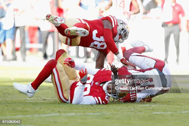 Larry Fitzgerald of the Arizona Cardinals makes a catch against Leon Hall of the San Francisco 49ers and Adrian Colbert of the San Francisco 49ers at...