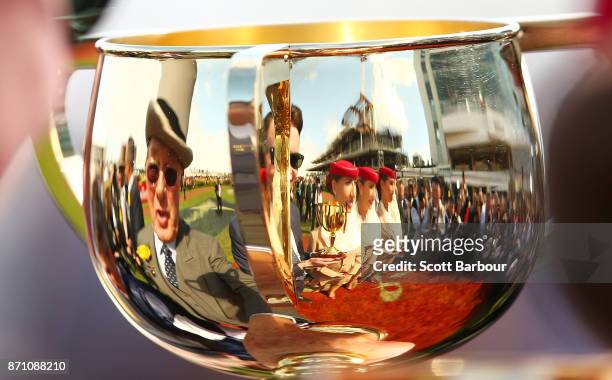 Owner Lloyd Williams and trainer Joseph O'Brien are reflected in the Melbourne Cup trophy after Rekindling ridden by jockey Corey Brown won race 7...