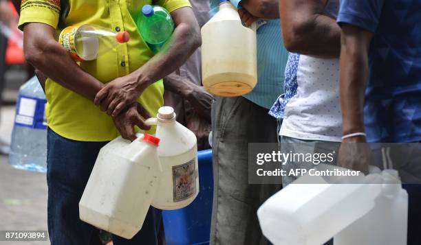 Sri Lankan commuters wait in a queue at a fuel station in Colombo on November 7, 2017. A Sri Lankan minister was forced on November 6 to apologise...